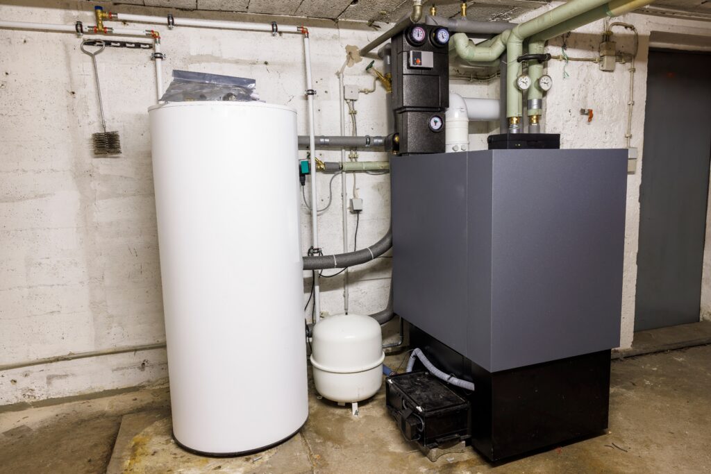 Basement HVAC system in a Litchfield County home with a boiler, hot water tank, and heating controls.